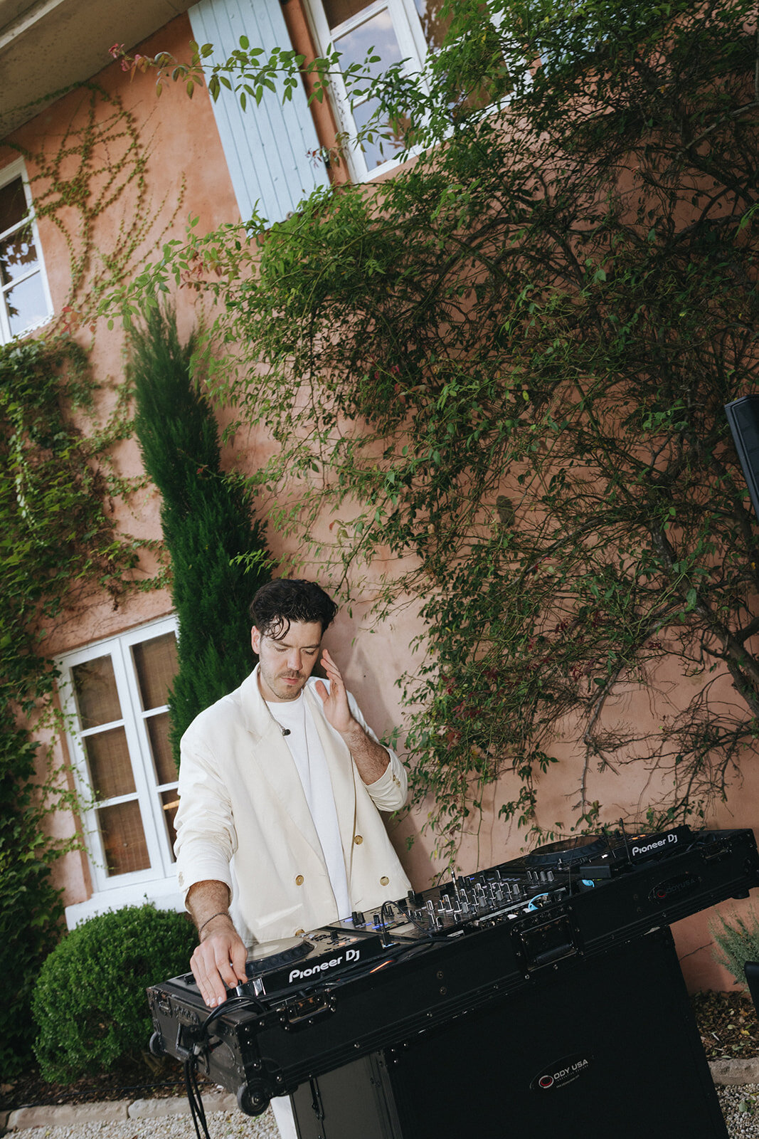 Josh Parish, founder of Married to the Groove, DJing outside a Melbourne wedding in a cream suit