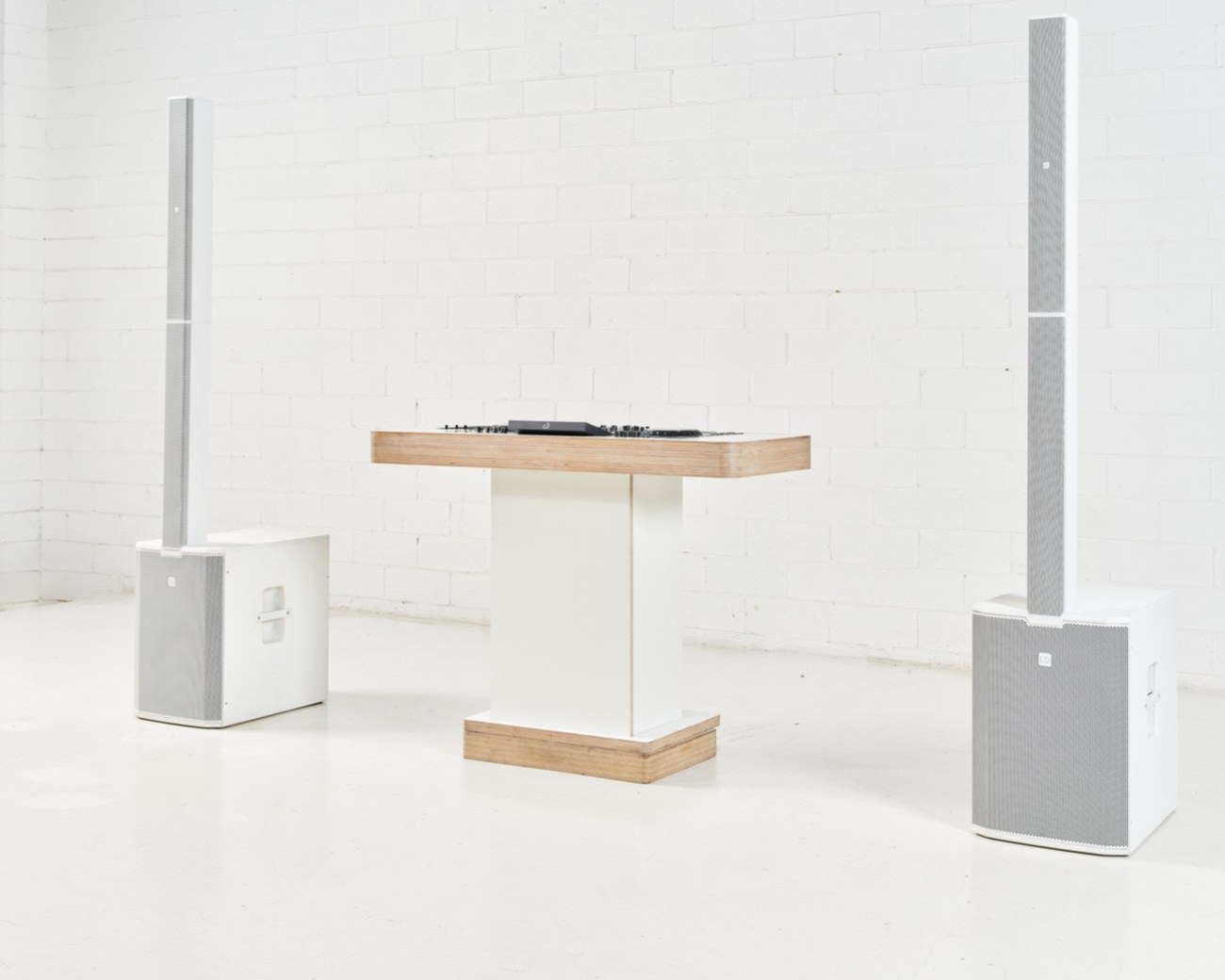 The custom white DJ booth and white speaker system