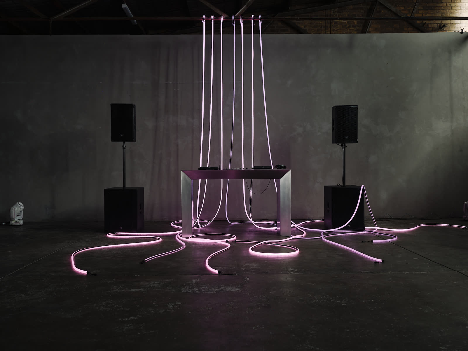 DJ setup lit in purple and pink tube lighting