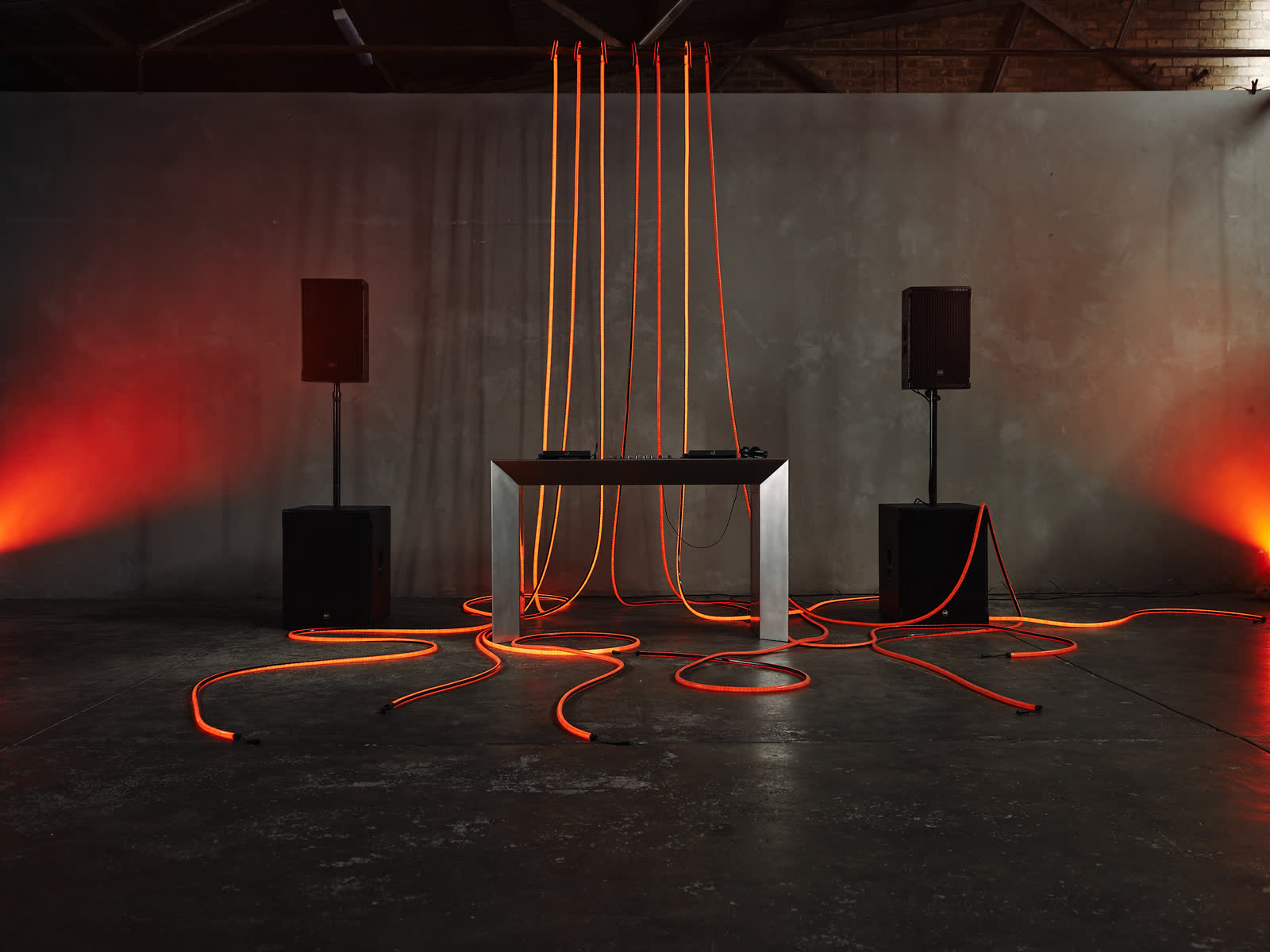 Red tube lighting with orange beams across the dancefloor